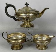 GEORGE V SILVER THREE PIECE TEA SERVICE of circular footed form, teapot with ebonised handle of