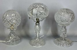 THREE CLEAR CUT GLASS TABLE LAMPS, early 20th century with circular spread feet, baluster columns