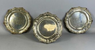 THREE VICTORIAN SILVER DINNER PLATES of circular lobed form, engraved with family crests and