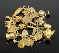 9CT GOLD CHARM BRACELET with over twenty charms, 38gms gross Provenance: private collection
