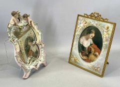 CONTINENTAL PORCELAIN ROCOCO FORM WALL MIRROR surmounted with two cherubs, 35 x 21cms and