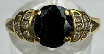 18CT GOLD RING set with dark sapphire and diamond chips to shoulders, size O, 4.0gms Provenance: