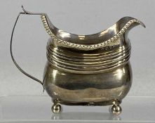 GEORGE III SILVER CREAM JUG of waisted form having a gadrooned border, on ball feet, London 1811,