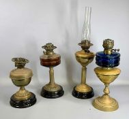 FOUR BRASS OIL LAMPS, late 19th century, three with black ceramic bases, one with blue glass
