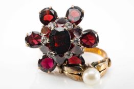TWO YELLOW METAL RINGS, one pearl set, the other garnet set with white gem chips, both unmarked (