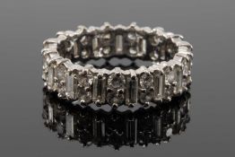 WHITE METAL DIAMOND ETERNITY RING, of alternating baguette (0.1cts each approx.) and round brilliant