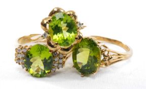 THREE 9CT PERIDOT DRESS RINGS, all mounted with oval cat stones, two the diamond shoulders, tot