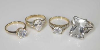 FOUR 14CT COLOURLESS GEMSTONE RINGS, comprising solitaire, solitaire with shoulder accents, large
