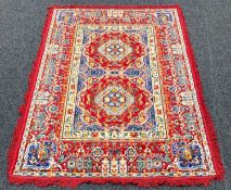 MOROCCAN SILK RUG, of traditional floral, foliate and geometric design on a red ground, with fringe,