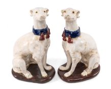 PAIR CONTINENTAL FAIENCE FIGURES OF GREYHOUNDS, seated on oval bases, 35cms (h) (2) Provenance: