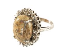 SILVER & FOSSIL DINOSAUR BONE RING, oval cabochon polished stone 15 x 11.5mm, within diamond-
