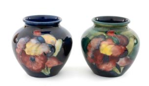 TWO MOORCROFT 'IRIS' PATTERN JARS, painted in early muted colours in green and blue colourways, 7.