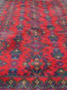 ANTIQUE TYPE RUG, red ground with blue and green geometric and floral patterns, 360 x 273cms