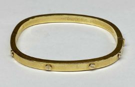 GOLD HINGED BANGLE of rounded rectangular form, stamped '750 Italy', 60 x 50mms internal, 14gms