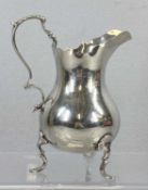 GEORGE V SILVER HELMET FORM CREAM JUG with wavy rim, acanthus capped scroll handle, on three