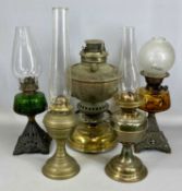 ASSORTED OIL LAMPS including three with cast iron bases and coloured glass reservoirs Provenance: