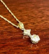 SOLITAIRE DIAMOND PENDANT, suspension loop mounted with two small diamonds and on 9ct yellow gold