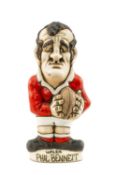 THE RUGBY UNION CLUB HOUSE: GROGG MODEL OF PHIL BENNETT BY JOHN HUGHES standing on titled base, in