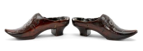 PAIR OF CARVED MINIATURE SHOES with floral engraved vamps and high heels, 14cms (l) Provenance: