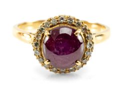 STAR RUBY & DIAMOND CLUSTER HALO RING. the ruby cabochon cut and set within a surround of circular-