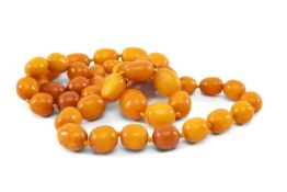 VINTAGE AMBER BUTTERSCOTCH BEAD NECKLACE of oval graduated form, 14mms smallest length, 22mms