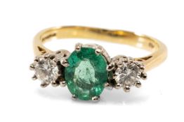 18CT GOLD EMERALD & DIAMOND THREE STONE RING, the central oval emerald (7 x 5mms approx.) flanked by