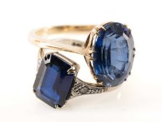 TWO BLUE SYNTHETIC SAPPHIRE RINGS, one stamped 'GOLD' & 'PLAT' with diamond chip shoulders, the