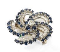 18CT WHITE GOLD DIAMOND & SAPPHIRE BROOCH of flower head spiral design, the central round cut