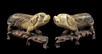 PAIR OF CHINESE CARVED STONE PIGS, striding on hardwood stands, 23cms (l) Provenance: private