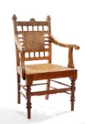 ANGLO-INDIAN HARDWOOD ARMCHAIR, foliate carved with woven rattan back and seat, turned front legs