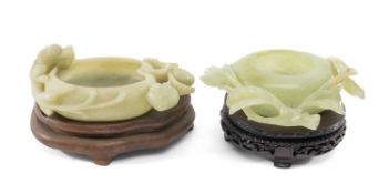 TWO CHINESE CARVED GREEN STONE BRUSH WASHERS, one rendered as peach with foliage, 11cms (w), the