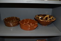 Three items of drip glazed terracotta, including bowl and two casserole dishes, in the manner of