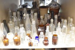 A large collection of vintage glass bottles and jars , including advertising bottles of interest
