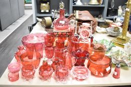 A collection of cranberry glass jugs, pinch pots, vase, glasses etc, also included are two
