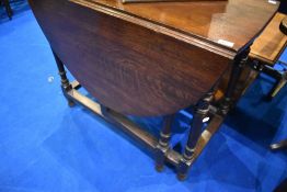 A traditional oak gate leg dining table having turned frame