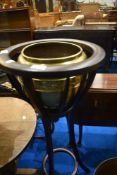 A hardwood jardiniere stand with brass planter