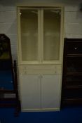 A white laminate display cabinet of slim proportions having two central drawers and cupboard under