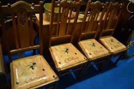 A set of four early 20th Century transitional golden oak dining chairs having later drop in seats