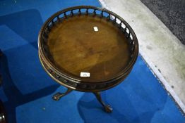A Reprodux tripod table having galleried top and ball and claw feet
