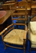 A stripped oak rush seated rocking chair