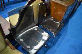 A pair of vintage chrome frame dining chairs with smokey perspex seats