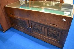 Ain interesting oak bijouterie style table with cupboard under, having lift top and campaign style