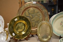 A 20th century Eastern copper charger, having pierced floral decoration, sold with a brass alms dish