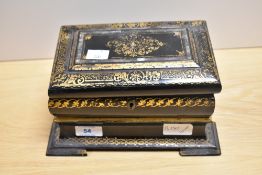 An early 19th Century black lacquered papier mache tea caddy, of sarcophagus form and decorated in