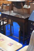 A traditional oak side table on turned H frame, approx 99 x 48cm, height 81cm