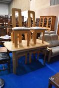 A modern light wood dining table and four chairs having stylised design , table approx. 139 x 80cm