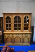 A modern pine bookcase having triple cupboard under, width approx. 175cm, height 170cm (base