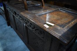 A period oak coffer having carved panel and frieze decoration , approx dimensions W133 D53 H58cm