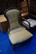 A Victorian mahogany framed nursing chair having later upholstery