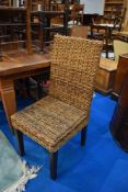 A set of twelve hardwood and wicker dining chairs